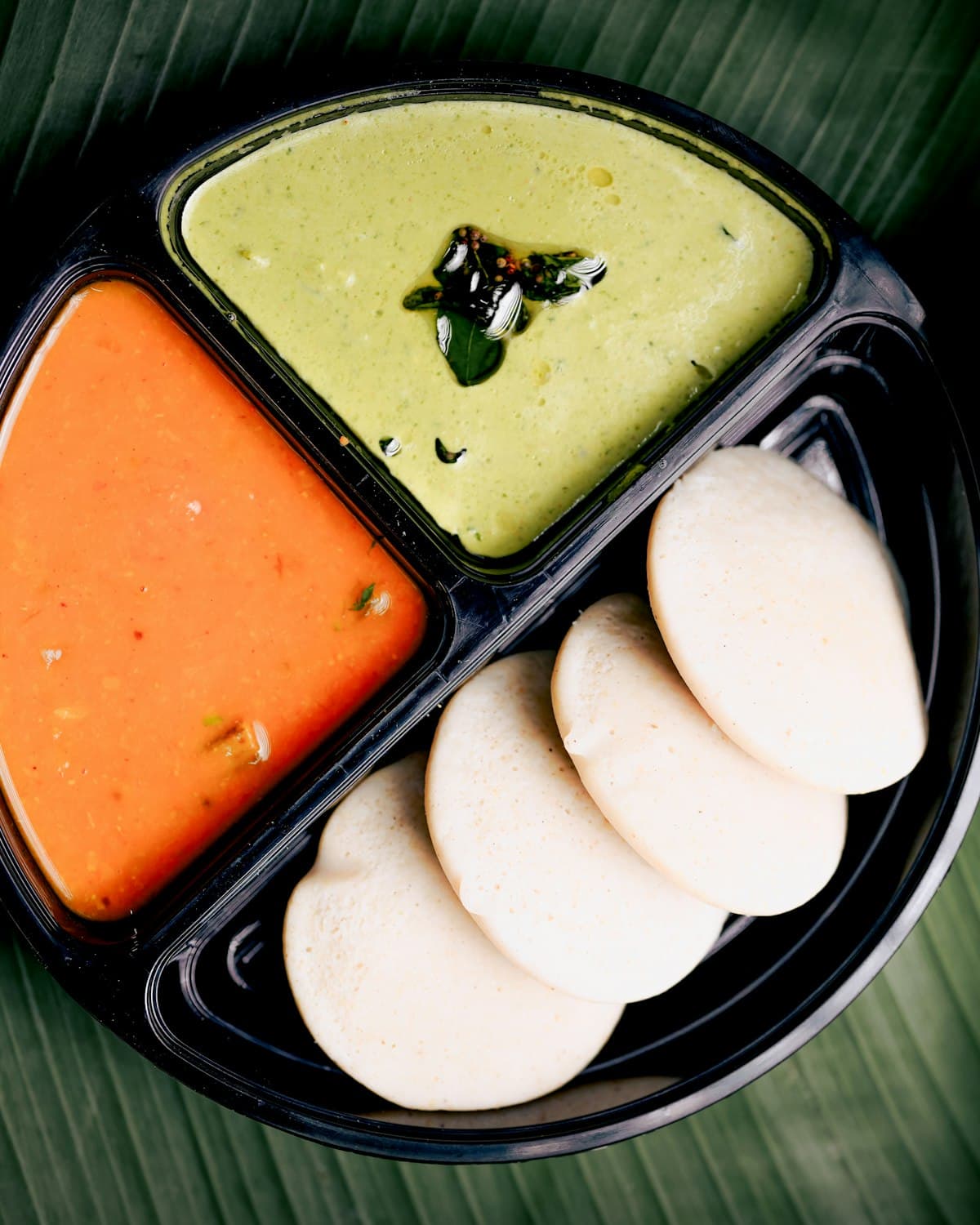 Dosa batter spread on a seasoned tawa in the kitchen